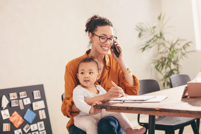 Happy woman with child working, talking on the phone