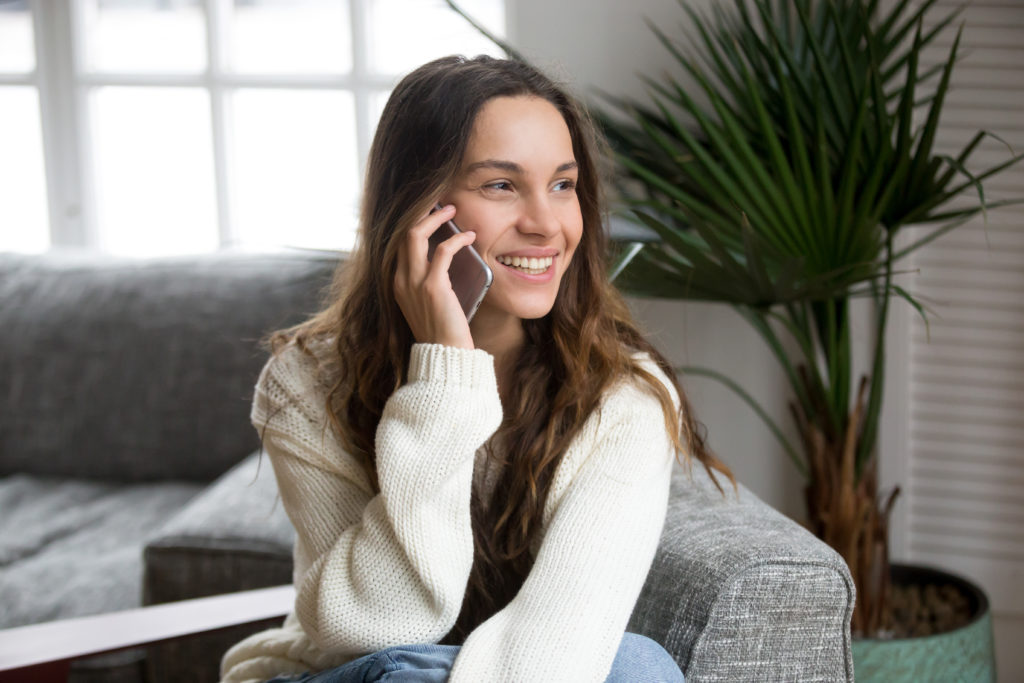 Smiling Millennial Woman Talking On The Phone At Home Happy
