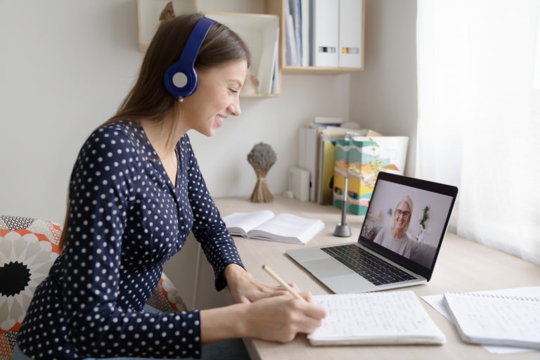 Rear View Businesswoman Wearing Headphones Working From Home Engaged In